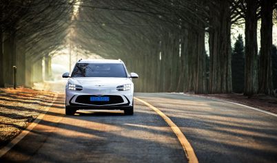 GRAYSCALE PHOTO OF A HYUNDAI IONIQ 5 IN THE RAIN