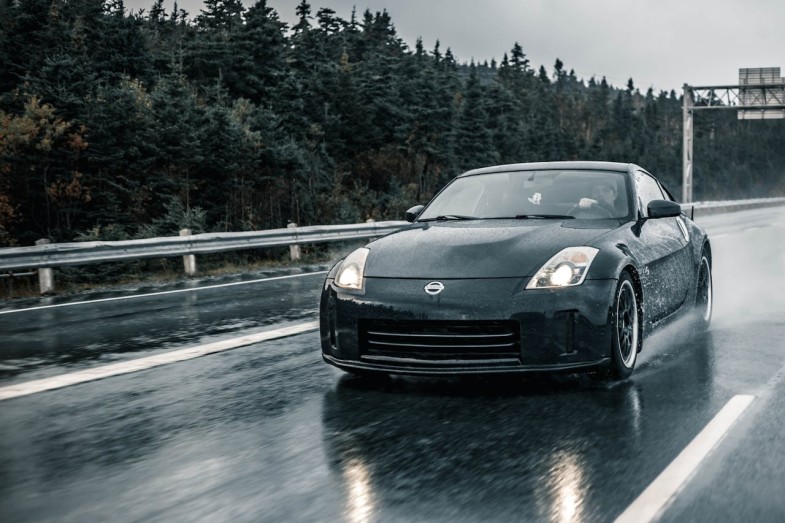 NISSAN A BLACK CAR ON WET ASPHALT ROAD