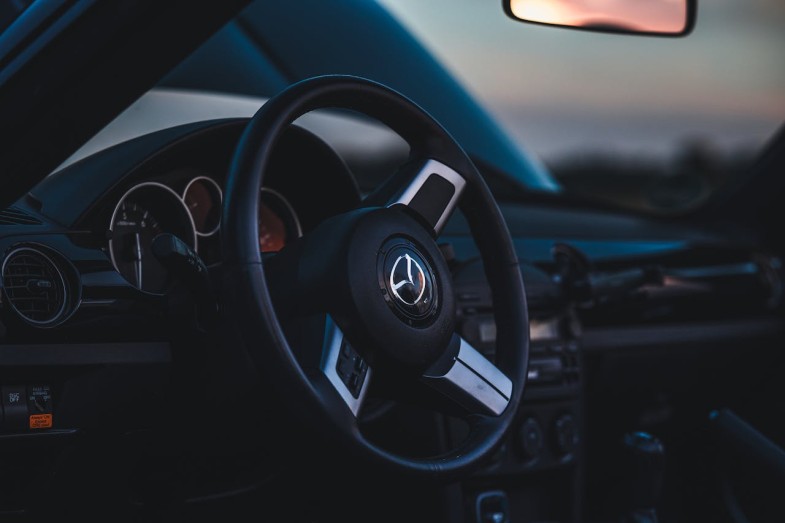 CLOSE UP OF THE STEERING WHEEL AND DASHBOARD IN A MODERN MAZDA MX-5