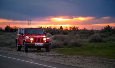 RED JEEP SUV BESIDE ROAD
