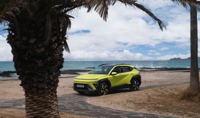 MODERN HYUNDAI KONA PARKED ON A BEACH NEAR PALM TREES