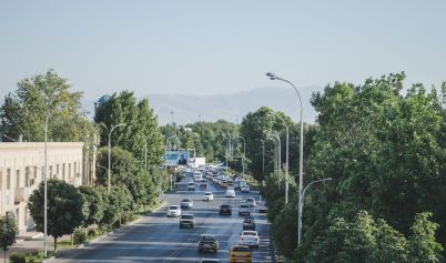 AERIAL VIEW OF A BUSY STREET BETWEEN GREEN TREES