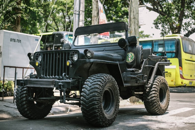 BLACK JEEP ACROSS YELLOW BUS
