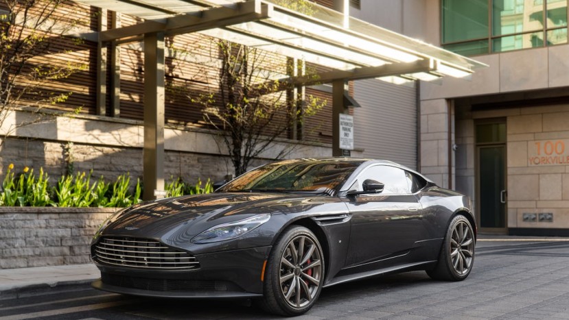 BLACK ASTON MARTIN PARKED NEAR BUILDING