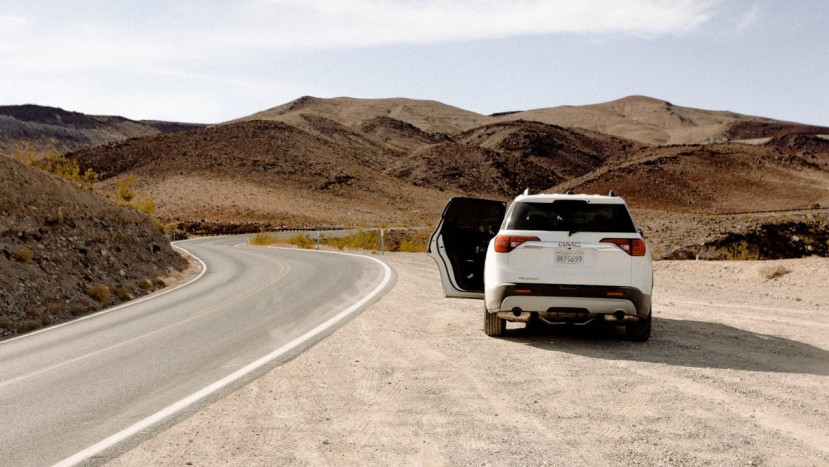 WHITE VEHICLE PARKED BESIDE ROAD,GMC