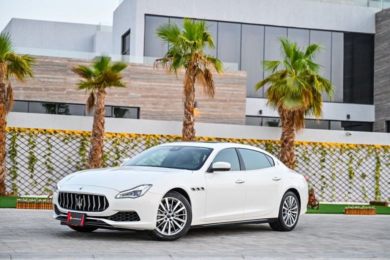 WHITE MASERATI CAR PARKED NEAR PALM TREES