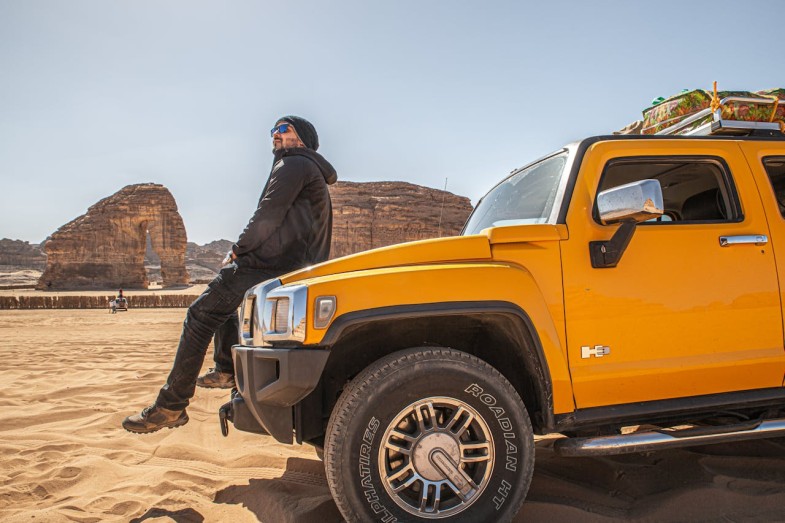 MAN SITTING ON A YELLOW HUMMER CAR