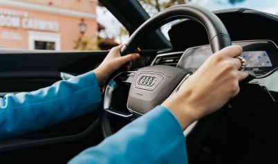 CLOSE UP OF WOMAN HOLDING THE WHEEL IN A NEW AUDI CAR