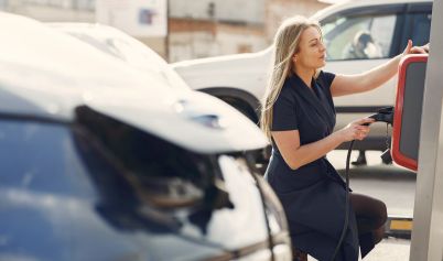 MODERN WOMAN USING STATION FOR CHARGING ELECTROMOBILE