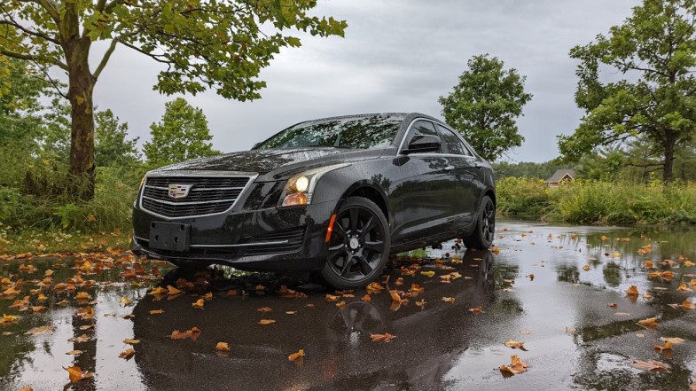 A BLACK CADILLAC CAR PARKED ON THE STREET