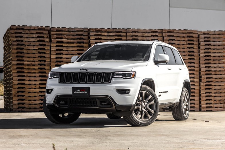 WHITE JEEP CHEROKEE SUV NEAR STACKED BROWN PALLET BOARDS
