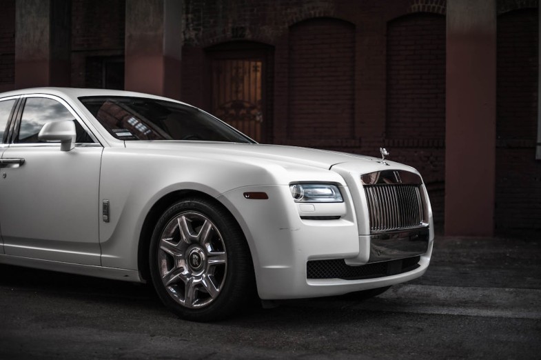PHOTO OF WHITE ROLLS-ROYCE GHOST PARKED NEAR BROWN BUILDING