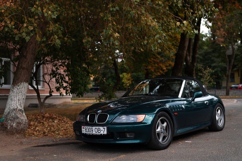 CONVERTIBLE BMW CAR PARKED ON THE STREET NEAR TREES