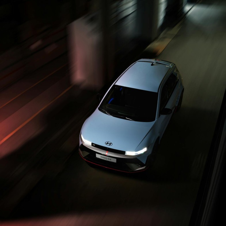 A HYUNDAI IONIQ 5 DRIVING ON A STREET AT NIGHT