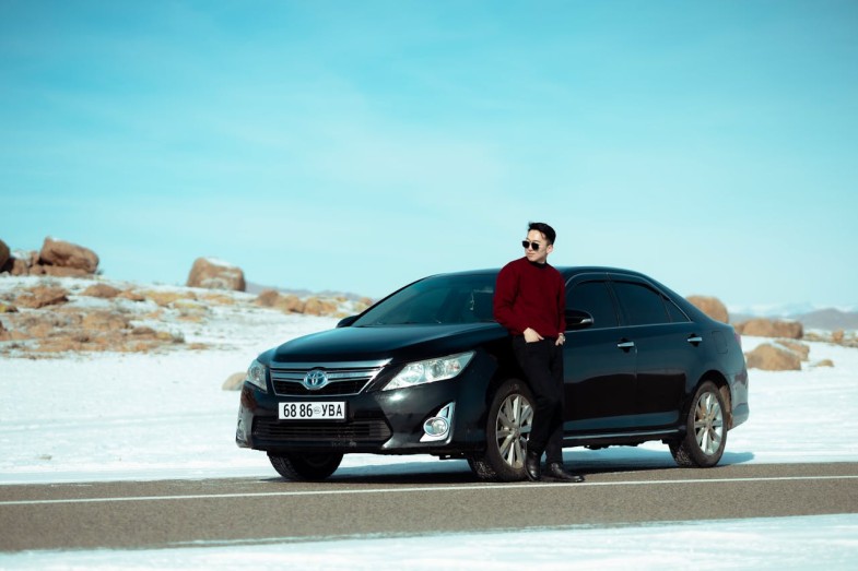 MAN IN FRONT OF BLACK TOYOTA ON A DESERT