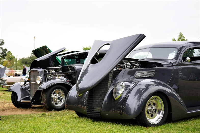 BLACK CLASSIC CARS ON SHOW ON A GRASS FIELD