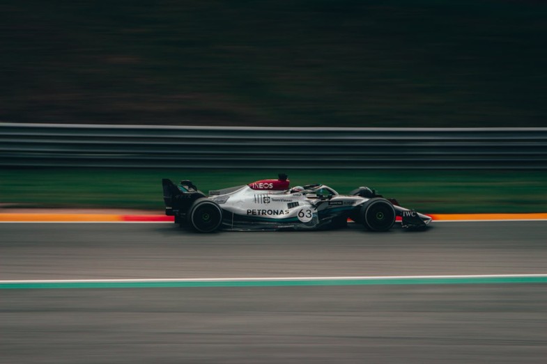 TIME LAPSE PHOTOGRAPHY OF GREEN AND WHITE RACING VEHICLE ON LANE
