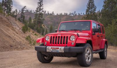 RED JEEP IN THE MIDDLE OF A DIRT ROAD