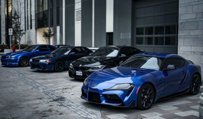 SPORTS CAR IN FRONT OF CAR SHOWROOM