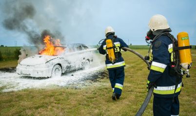 FIREMEN SPRAYING ON FLAMING VEHICLE