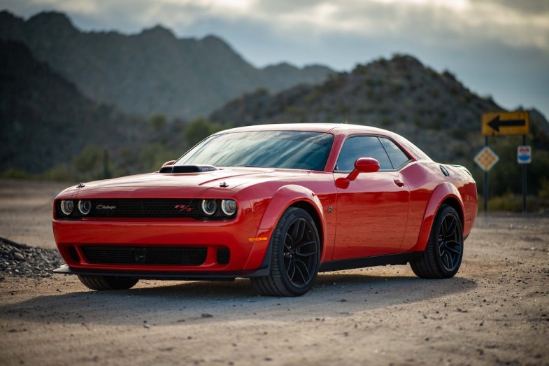 RED DODGE CHALLENGER PARKED ON UNPAVED ROAD
