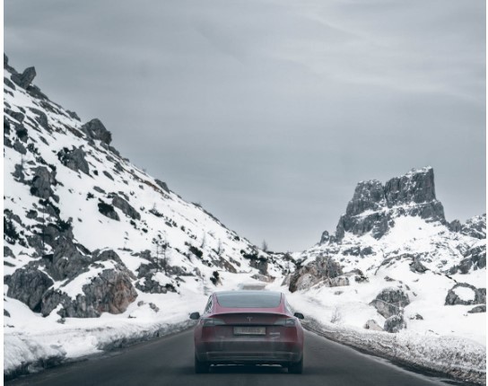TESLA CAR ON GRAY ASPHALT ROAD