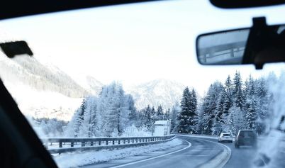 ROAD BETWEEN SNOW COVERED TREES