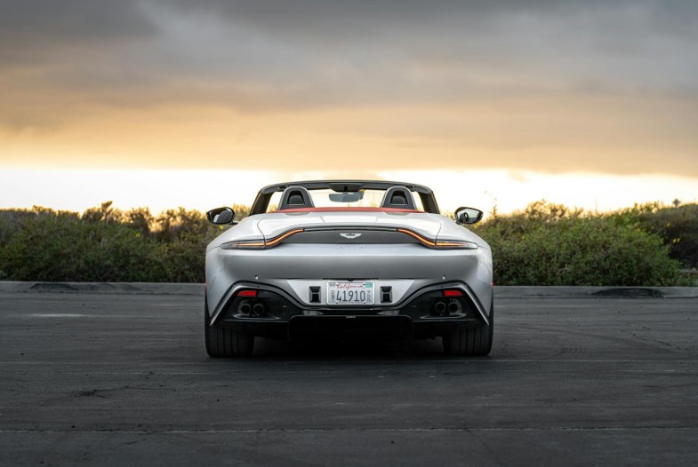 GRAY ASTON MARTIN ON THE ROAD DURING SUNSET