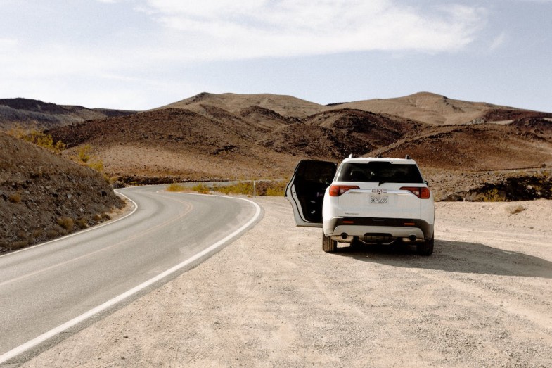 WHITE VEHICLE PARKED BESIDE ROAD,GMC