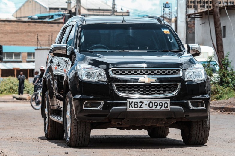 A BLACK CHEVROLET ON THE ROAD