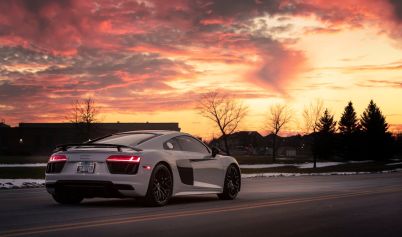 A WHITE SPORTS CAR ON THE ROAD AUDI