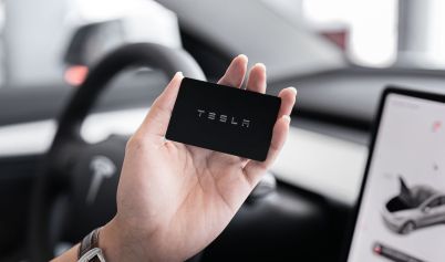 PERSON HOLDING A BLACK CARD TESLA